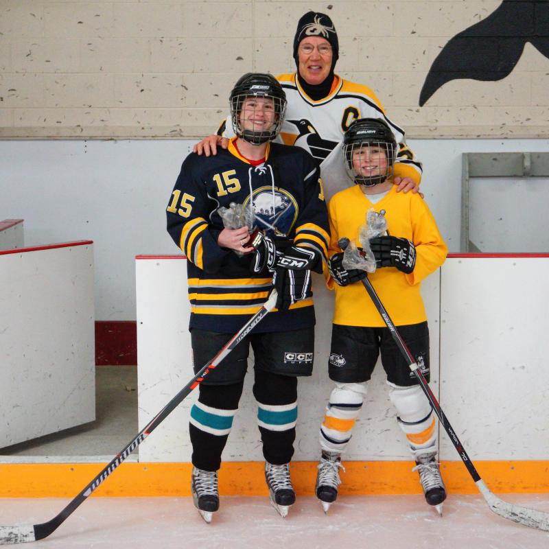 Managing Director and head coach of Hockey Unlimited Tim Dyer congratulates Alicia Wohlgemuth (left) and Joy Mello (right) for receiving the Most Improved Player award. BY HOCKEY UNLIMITED